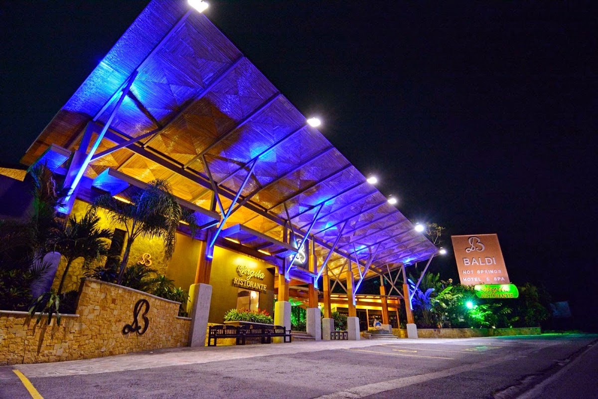 Illuminated entrance of Baldi Hot Springs at night
